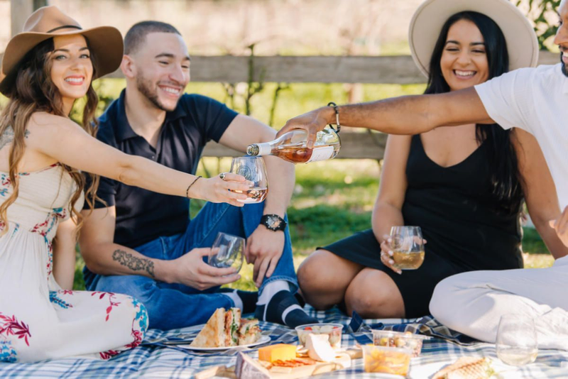 Friends enjoying a picnic with V. Sattui wine and food.