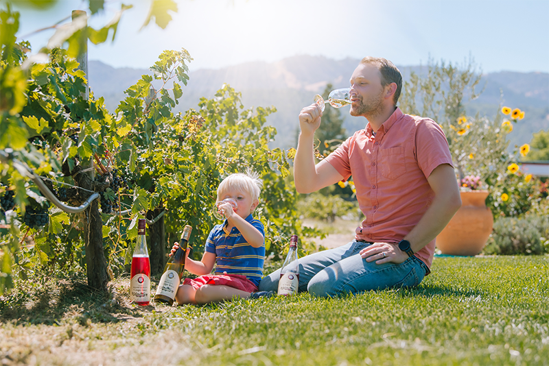 Winemaker Jason Moravec and son enjoying juice in the vineyard.