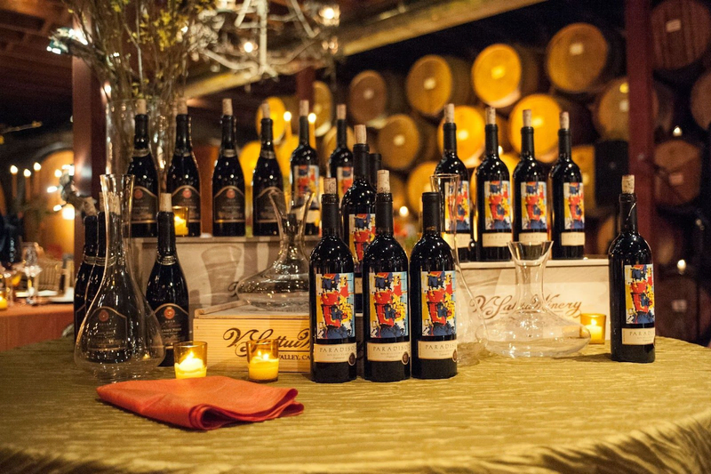 Elegant wine display with bottles, decanters, and candles in a cellar.